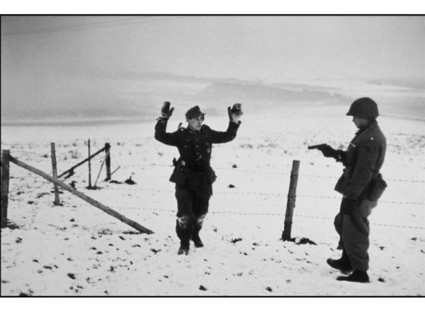 Un soldat américain et un prisonnier de guerre allemand durant la bataille des Ardennes, près de Bastogne, Belgique, décembre 1944. ©Robert Capa @International Center of Photography/Magnum Photos